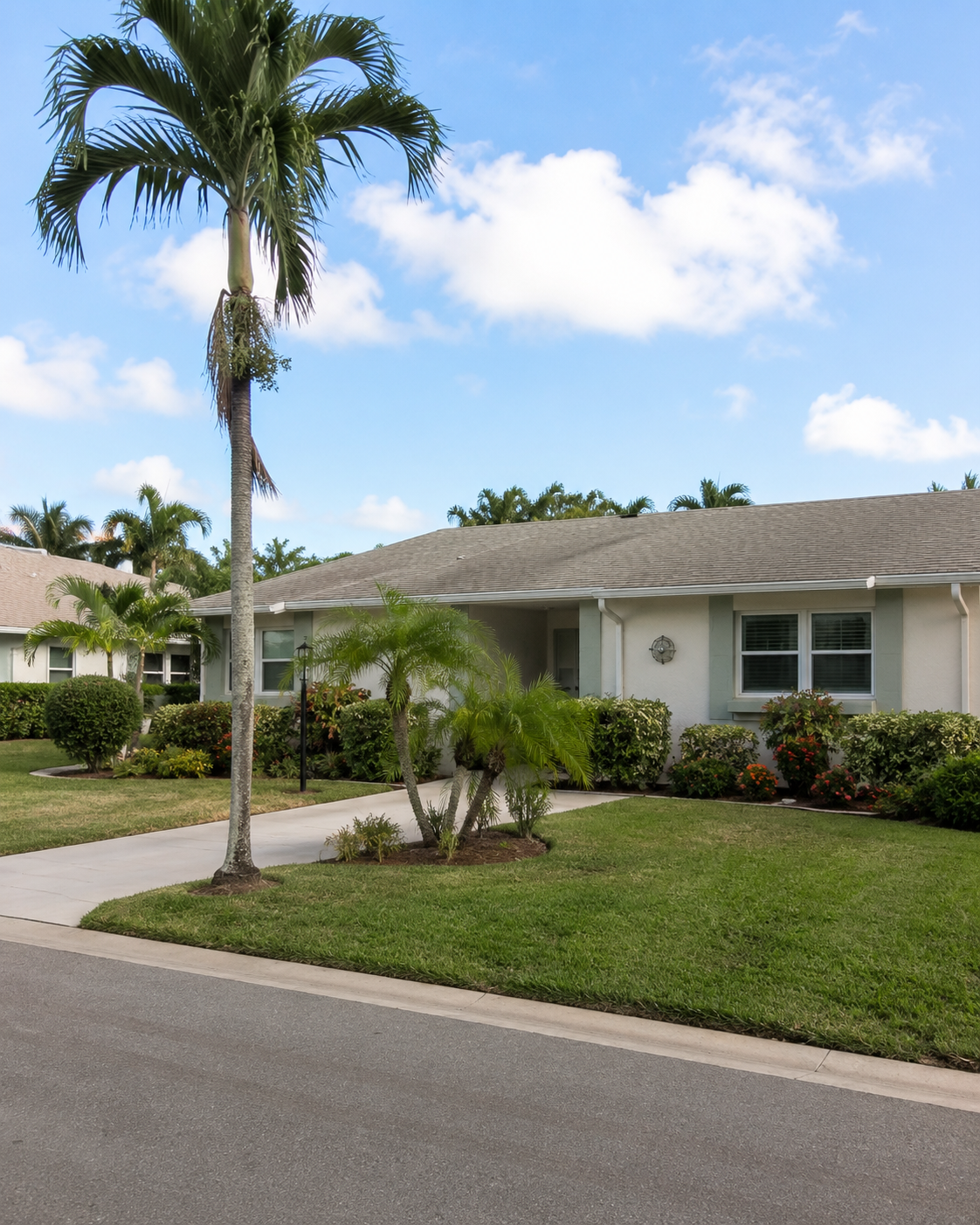 Single-story villa on a palm-lined street in the Leisureville community, Boynton Beach